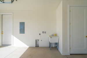 Laundry area with electric panel, concrete flooring, washer hookup, and electric dryer hookup