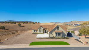 View of front facade with stucco siding, a mountain view, and driveway