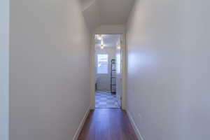Hall with baseboards and dark wood-style flooring