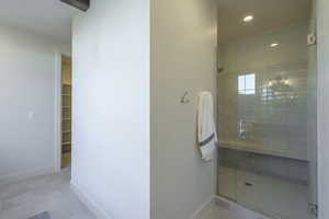 Bathroom with a walk in closet, a stall shower, light tile patterned flooring, and recessed lighting