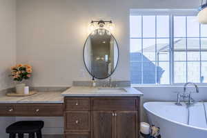 Bathroom featuring vanity, a soaking tub, and a shower stall