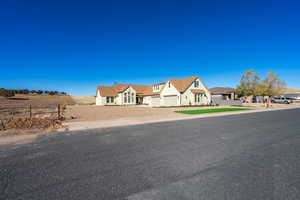View of front of house featuring driveway, a garage, and stucco siding