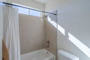 Bathroom with shower / tub combo and toilet