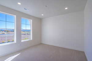 Spare room featuring light colored carpet and recessed lighting