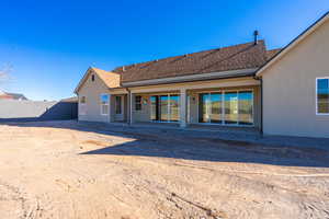 Back of property with a patio, a shingled roof, a fenced backyard, and stucco siding