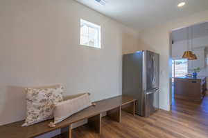 Kitchen with healthy amount of natural light, freestanding refrigerator, dark wood finished floors, and dark countertops