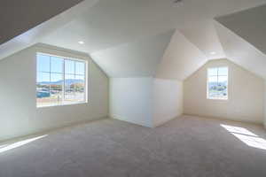 Bonus room with vaulted ceiling, carpet, a mountain view, and recessed lighting