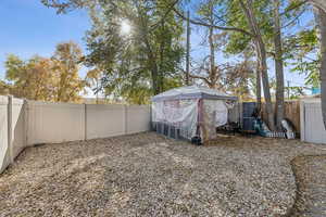 Fenced backyard featuring an outbuilding