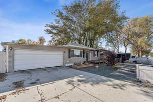 Ranch-style home with concrete driveway and an attached garage