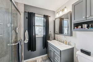 Full bathroom featuring light tile patterned floors, vanity, a stall shower, and a textured ceiling