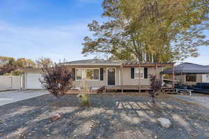 Ranch-style house with driveway, a deck, and an attached garage