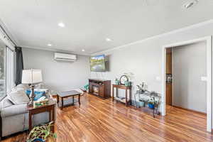 Living room featuring ornamental molding, light wood finished floors, recessed lighting, and a textured ceiling