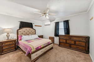 Bedroom featuring crown molding, light colored carpet, a textured ceiling, and a ceiling fan
