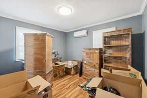 Office area featuring wood finished floors, ornamental molding, and a textured ceiling