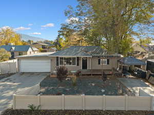 View of front of home featuring a fenced front yard, driveway, a garage, a mountain view, and a residential view