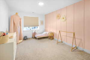 Bedroom featuring light carpet and baseboards