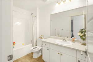 Bathroom featuring shower / bath combo with shower curtain, vanity, and light wood-type flooring