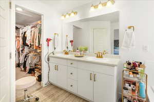 Full bathroom featuring double vanity and a walk in closet