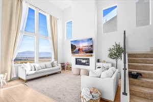 Living room featuring stairway, wood finished floors, and a high ceiling