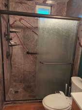 Bathroom featuring a marble finish shower and vanity