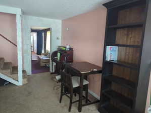 Office space featuring a textured ceiling and light colored carpet