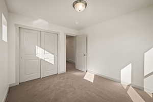 Unfurnished bedroom featuring carpet floors and a closet