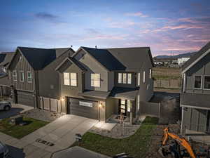View of front of home featuring an attached garage, roof with shingles, concrete driveway, and stucco siding