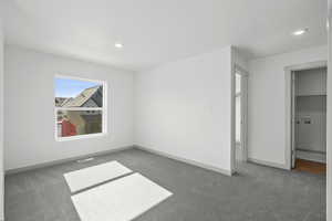 Unfurnished bedroom with carpet flooring, recessed lighting, and a baseboard radiator