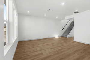 Spare room with stairway, light wood finished floors, and recessed lighting