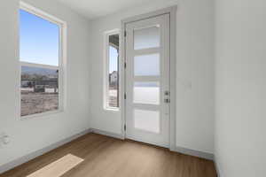 Doorway featuring wood finished floors and baseboards