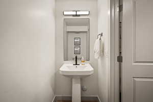 Bathroom featuring baseboards and dark wood finished floors