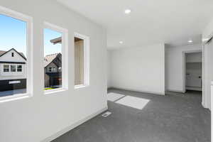 Carpeted empty room with recessed lighting and baseboards