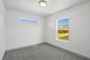 Empty room featuring carpet floors and a mountain view