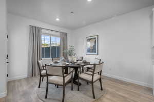 Dining room with light wood-style flooring and recessed lighting