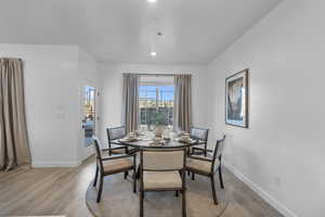 Dining space with light wood-style floors and recessed lighting