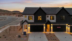 Modern farmhouse featuring driveway, stucco siding, and an attached garage