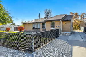 Rear view of property featuring brick siding, a patio, and a shingled roof