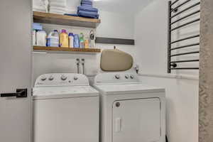 Washroom with washer and dryer and radiator heating unit