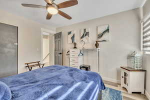 Bedroom with light wood finished floors and a ceiling fan