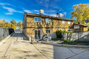 Rear view of house featuring a fenced backyard, brick siding, and driveway