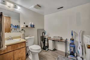 Bathroom featuring vanity, light wood finished floors, and washer / dryer