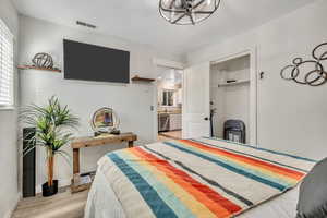Bedroom with a closet, light wood-style flooring, and a chandelier