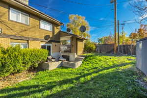 Back of house featuring brick siding, a fenced backyard, and a patio