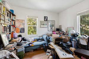 Office with wood finished floors and healthy amount of natural light