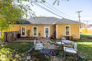 Back of property featuring roof with shingles, a patio area, and an outdoor fire pit