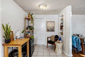 Sitting room with light tile patterned flooring and built in shelves
