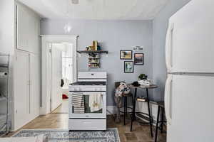 Kitchen with white appliances and open shelves