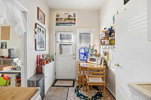 Foyer entrance with stone finish floors and baseboards