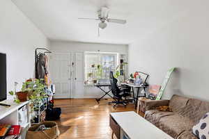 Living area featuring an office area, light wood-style flooring, and ceiling fan
