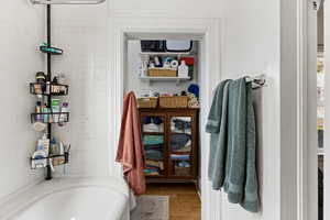 Bathroom with wood finished floors and a tub